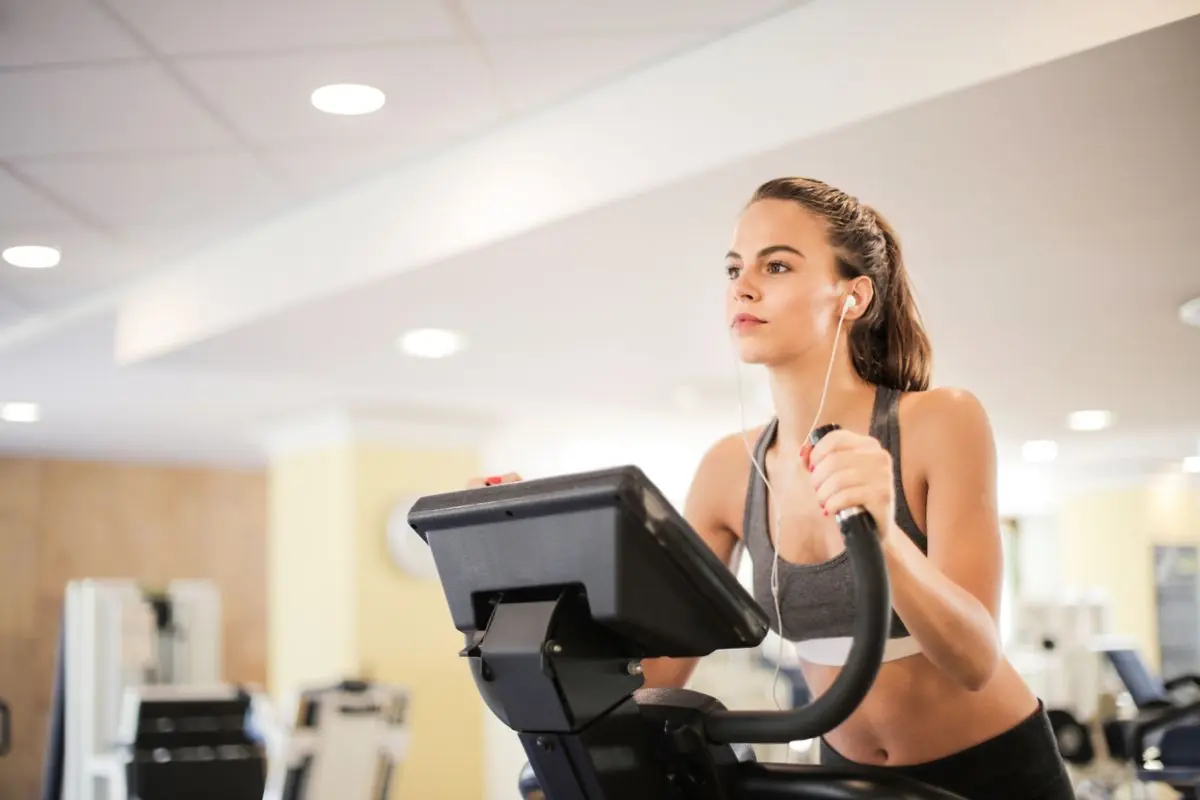 Woman training on a cardio machine in a bright gym