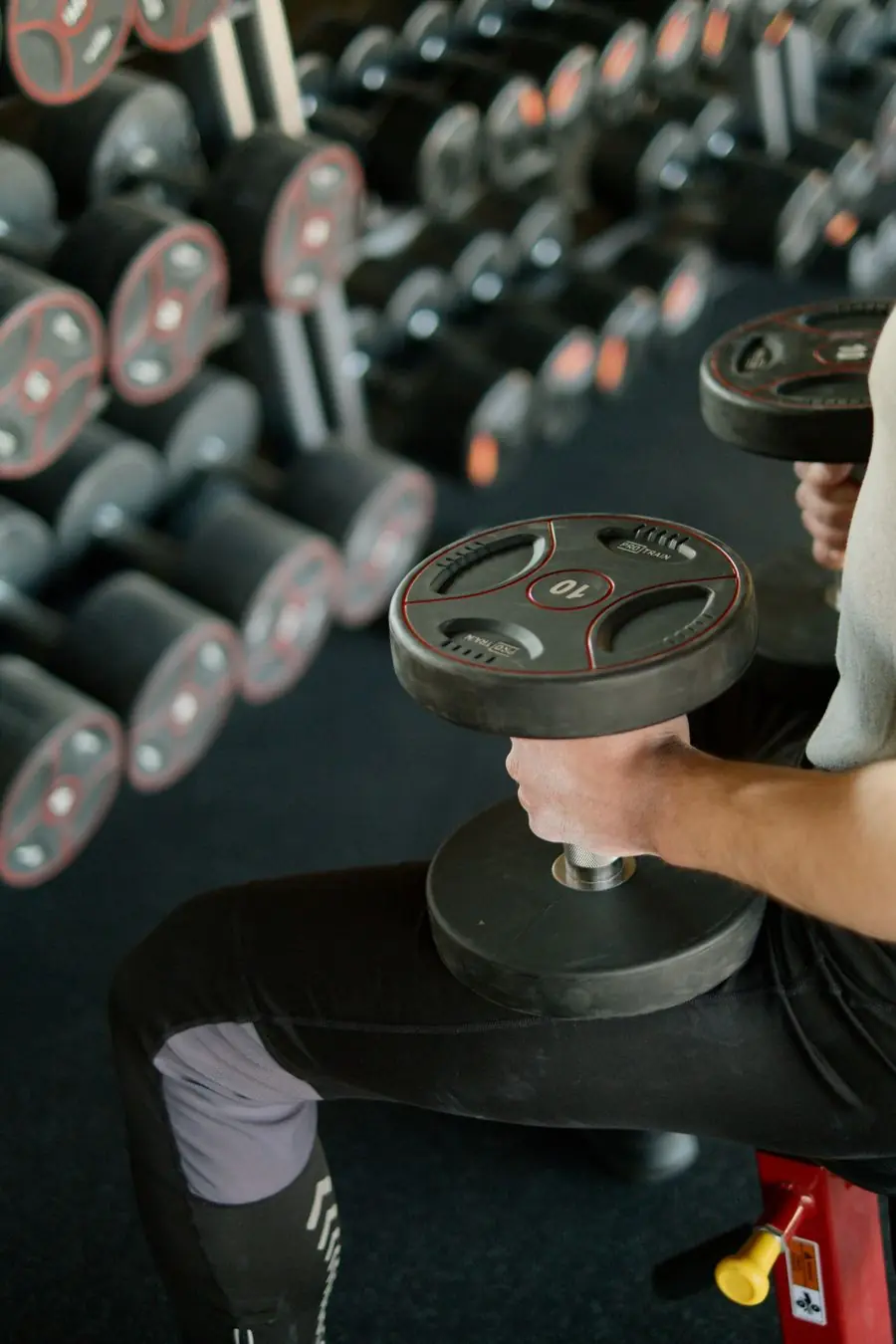 Trainer picking a dumbbell from the rack before a set