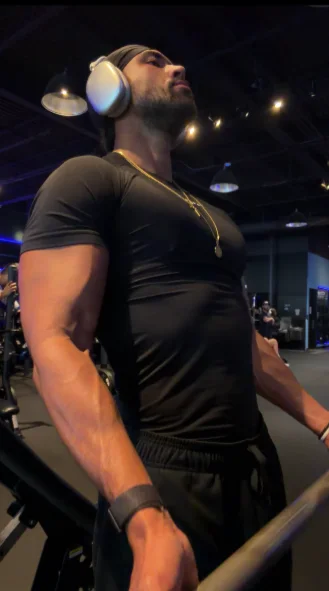 Jordan mid-set in the gym, wearing headphones